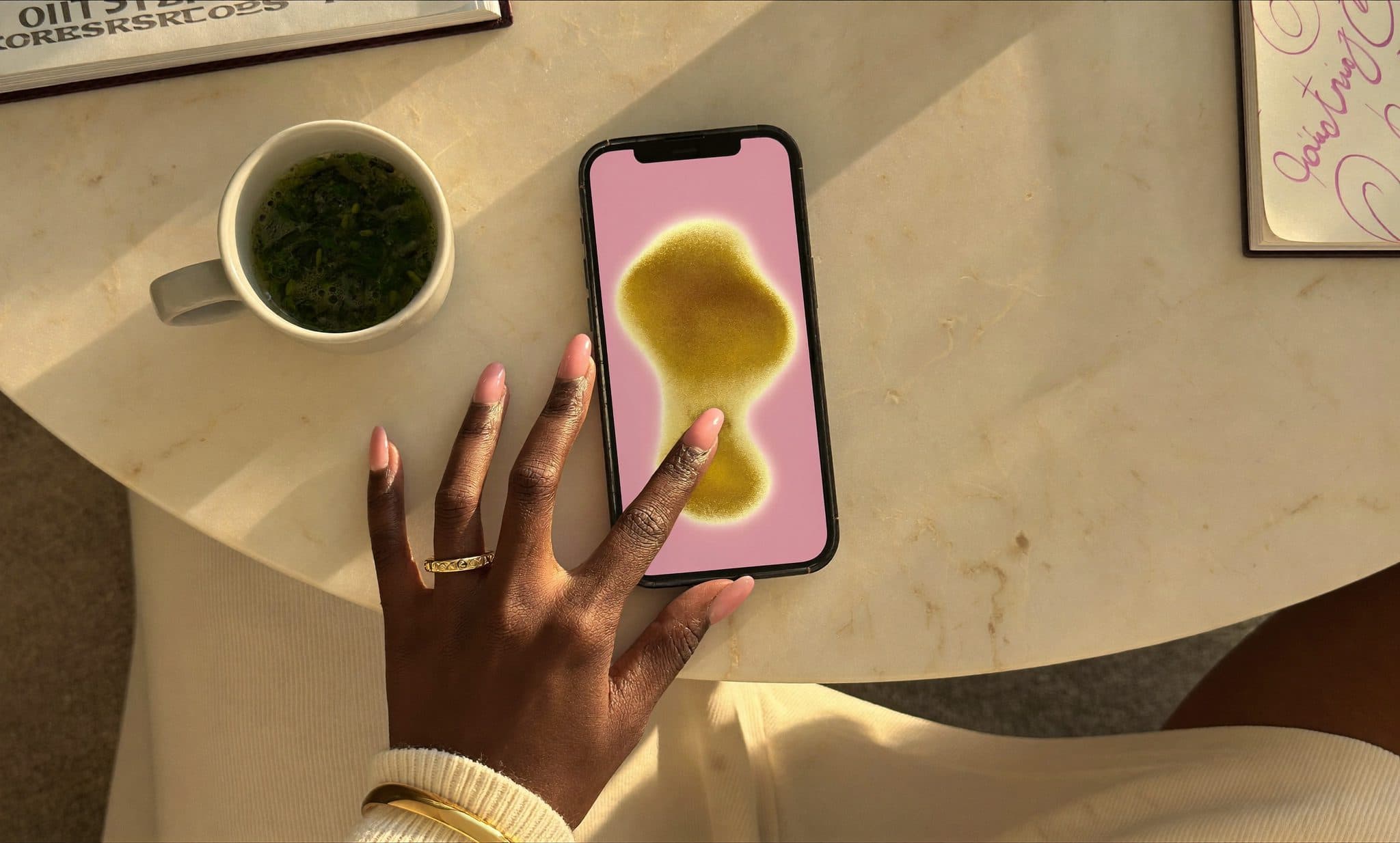 Cloche dorée vintage sur marbre crème avec anneaux d'or représentant les ondes sonores, pétales de rose — métaphore des notifications live